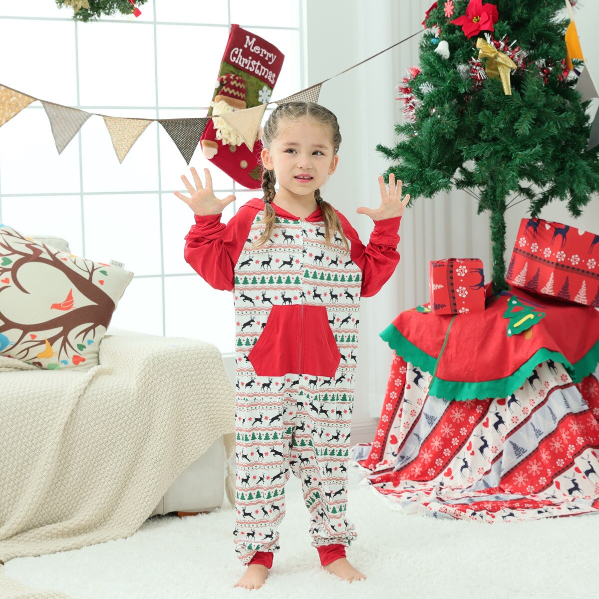 Parents and child in matching polyester Christmas tree pattern rompers, celebrating holiday gifts.
