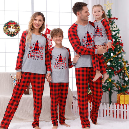 Dad, mom, and baby wearing coordinated red plaid Christmas pajamas, cozy holiday sleepwear.