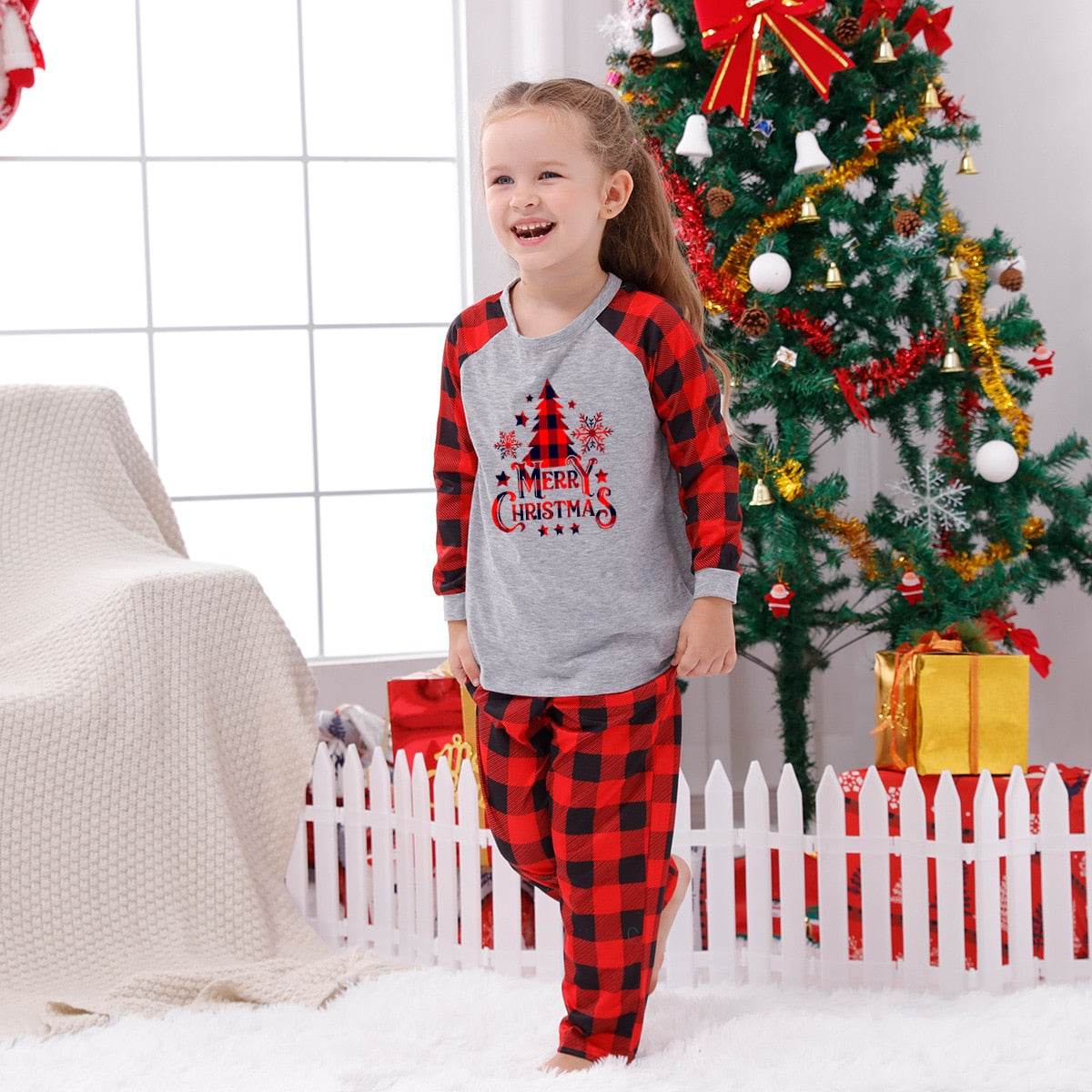 Mother and daughter in matching red plaid Christmas pajamas, festive family outfits.