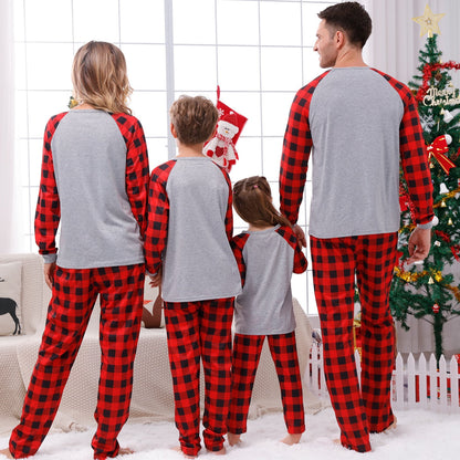 Stack of folded red plaid Christmas pajamas in various sizes for family matching outfits, cotton.