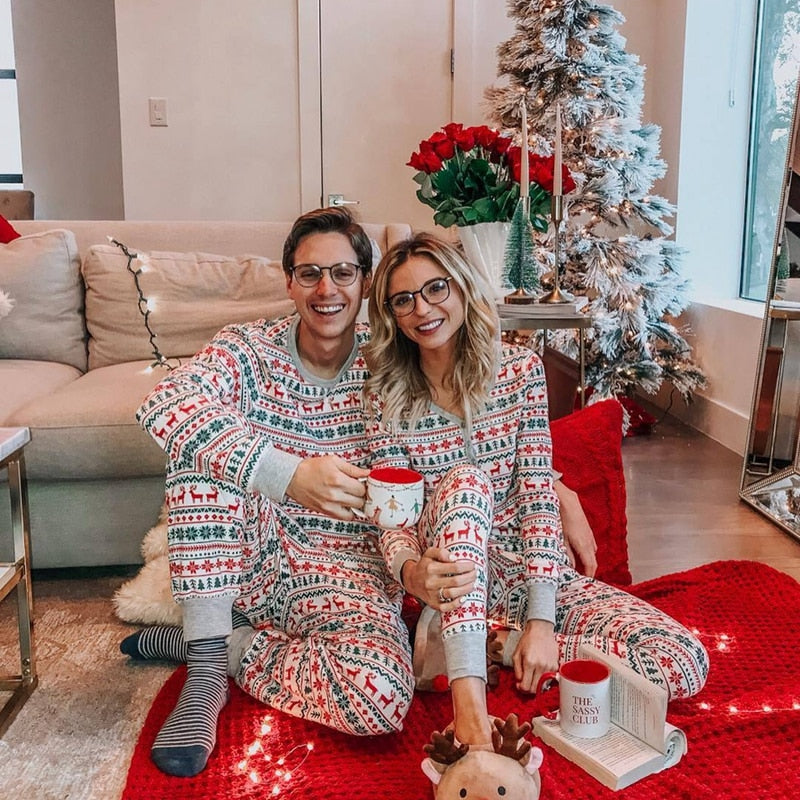 Adult holding a cup, showcasing soft fabric of red and white striped Christmas pajamas.