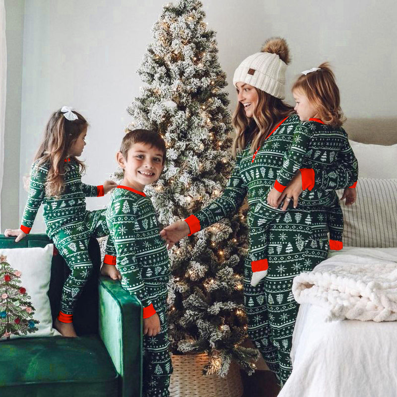 Teenagers and children in matching family Christmas pajamas, playing a board game.