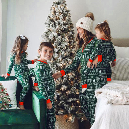 Teenagers and children in matching family Christmas pajamas, playing a board game.