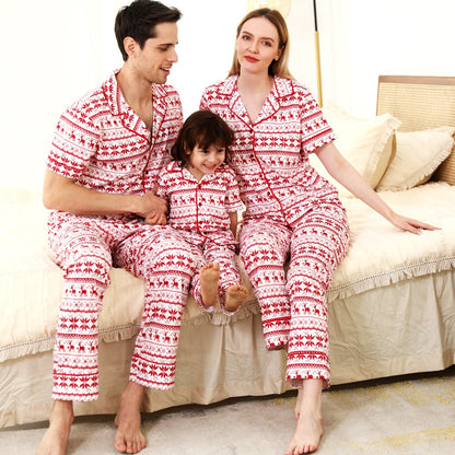 Family in matching red short-sleeve polyester Christmas pajamas laughing together at home