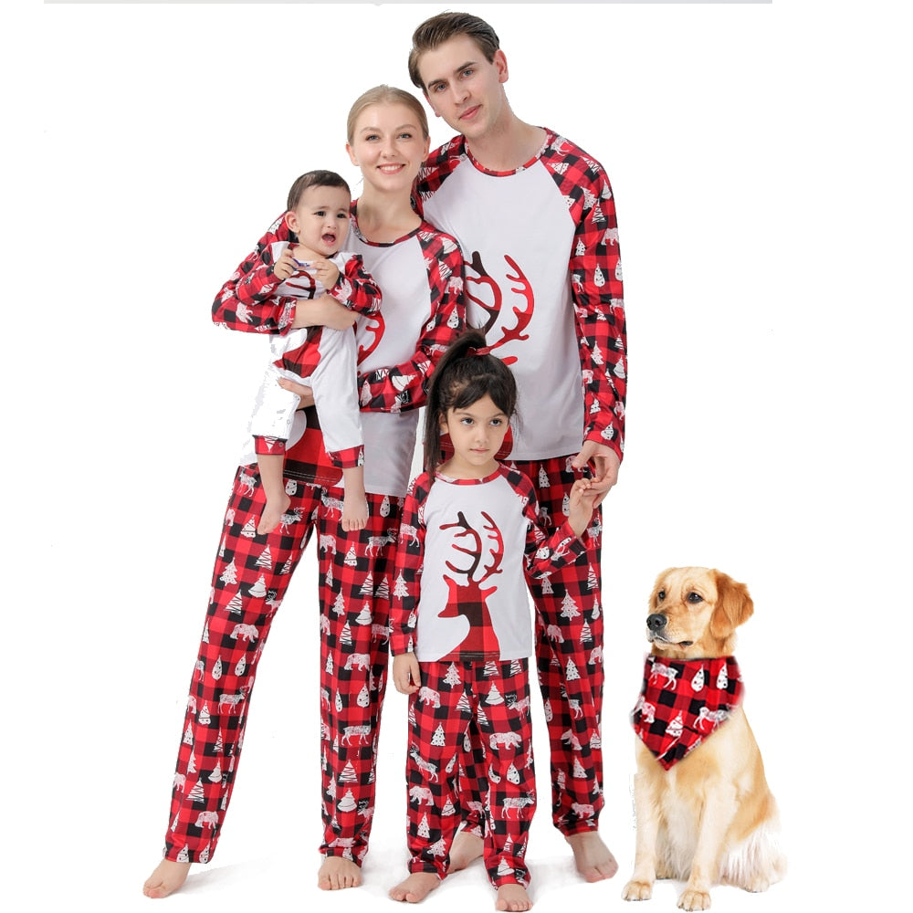 Family in red & black plaid Christmas pajamas, dog in matching bandana, holiday sleepwear set.