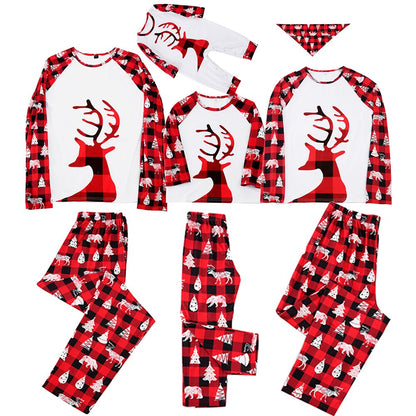 Happy family of four plus pet dog in festive matching Christmas plaid pajamas, holiday outfits.
