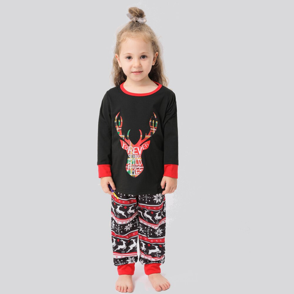 Adult woman wearing red elk print Christmas pajamas, holding hot cocoa, winter festive sleepwear
