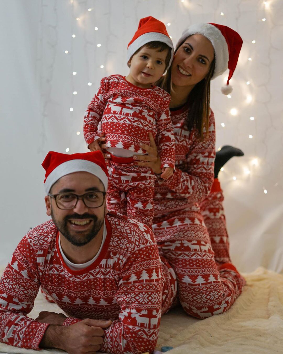 Happy family opening gifts in matching red Christmas pajamas, perfect holiday sleepwear moments