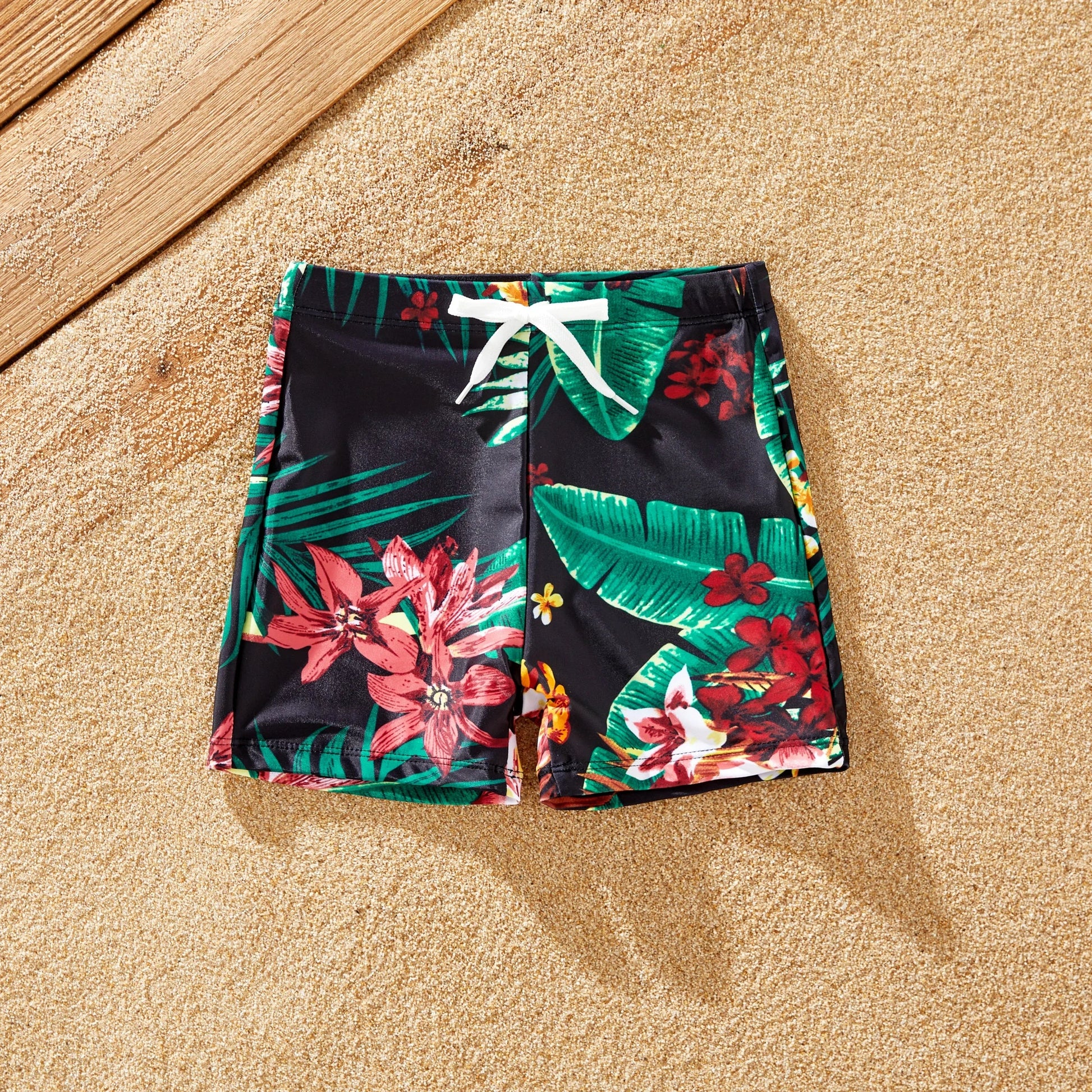 Close-up of quick-dry polyester family swimwear with vibrant tropical print.