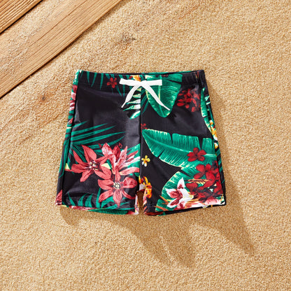 Close-up of quick-dry polyester family swimwear with vibrant tropical print.