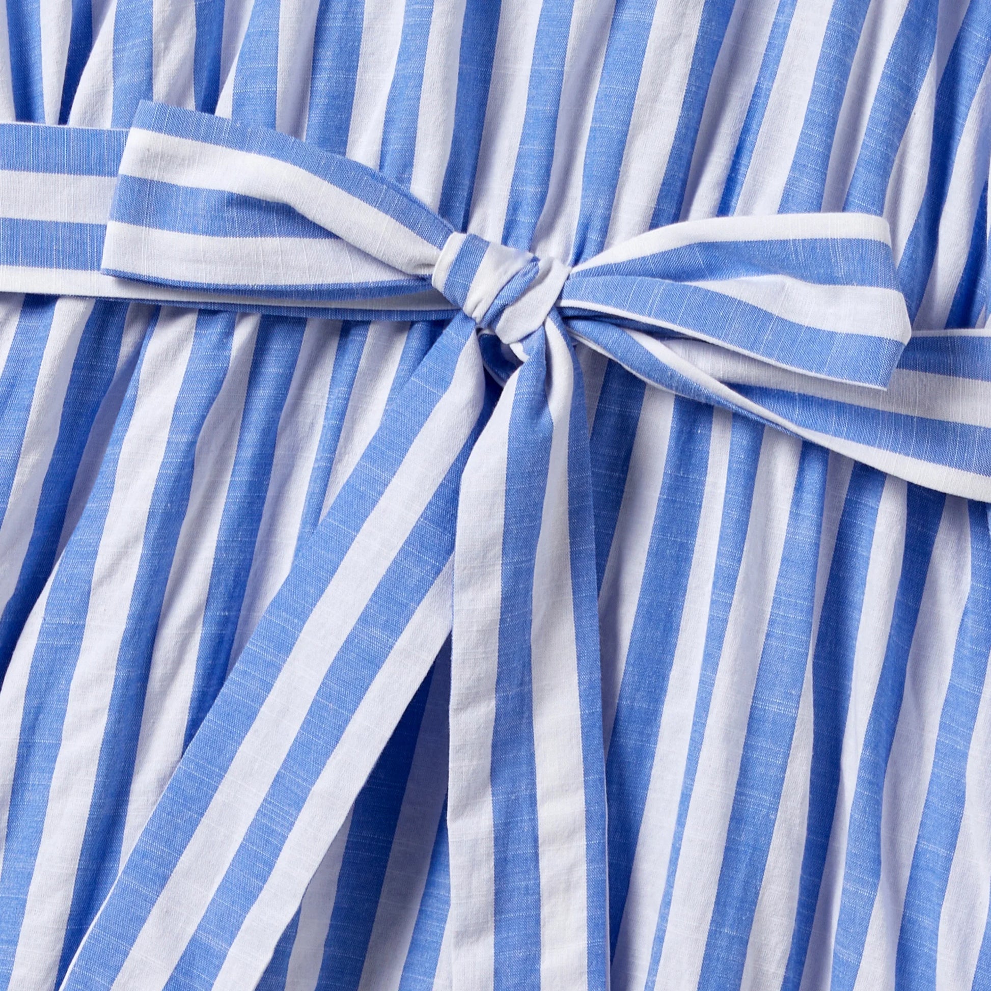 Back view of family in matching stripe outfits, showcasing the coordinated design and tassel trim.