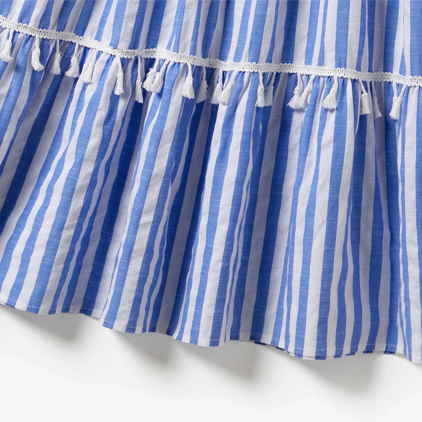 Mother and daughter posing in their elegant blue and white stripe tassel-trimmed summer dresses.