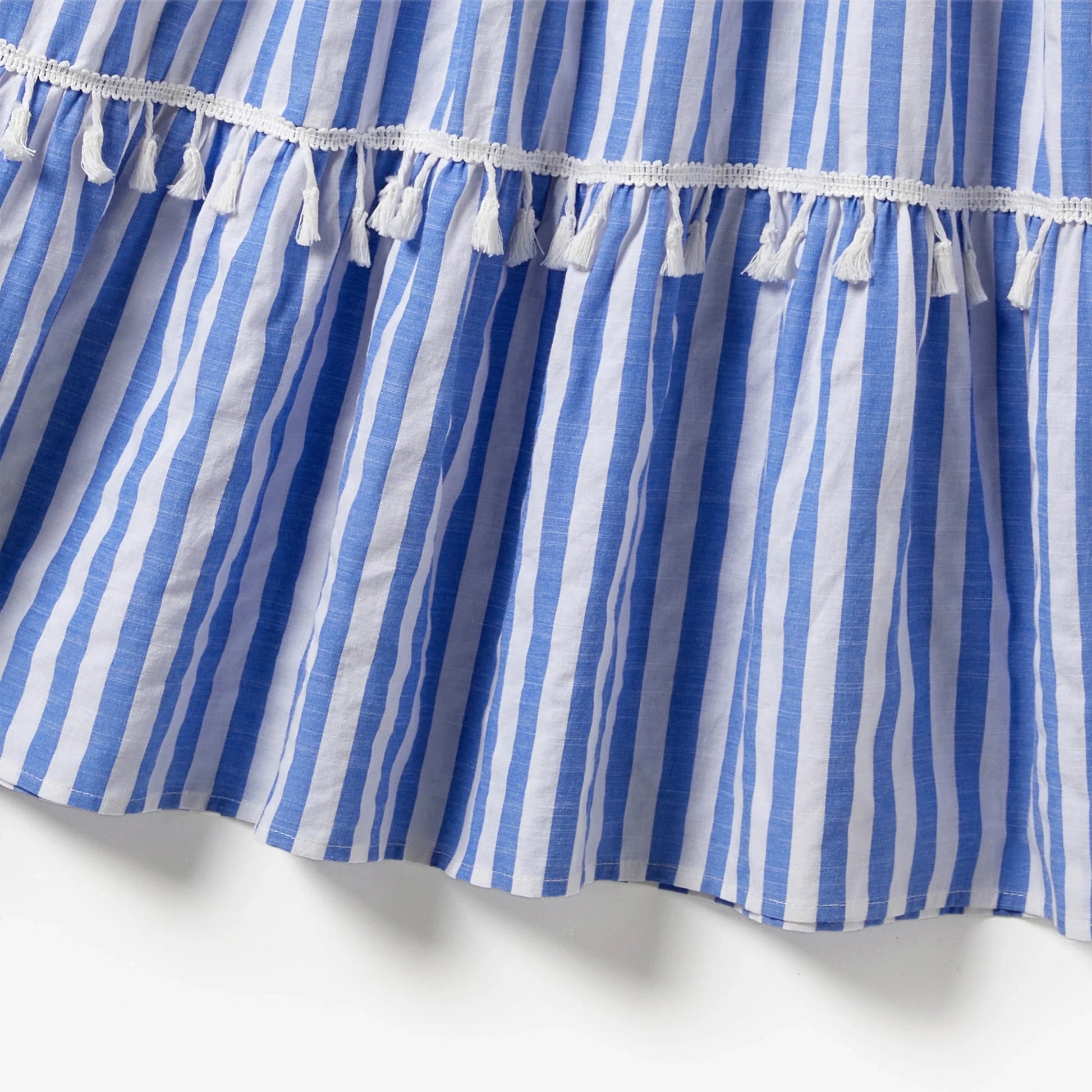 Mother and daughter posing in their elegant blue and white stripe tassel-trimmed summer dresses.