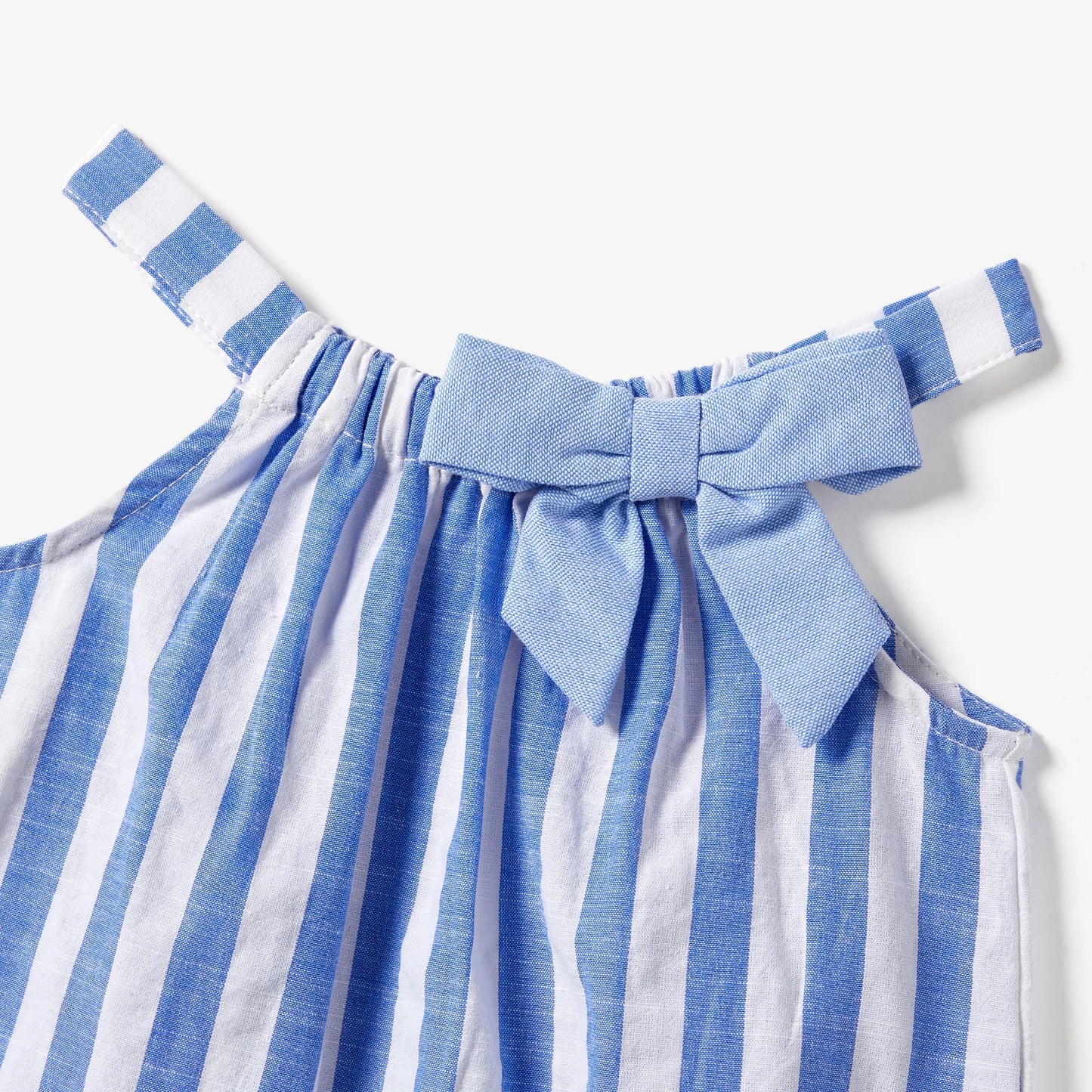 Coordinated family outfits: mom and daughter stripe dresses, dad and son stripe shirts with tassels.