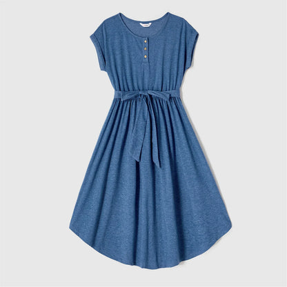 Family photoshoot wearing blue belted dresses and striped t-shirts, matching summer clothing casual