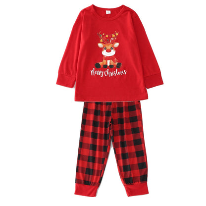 Happy family in coordinated Christmas outfits, posing together in matching holiday pajamas