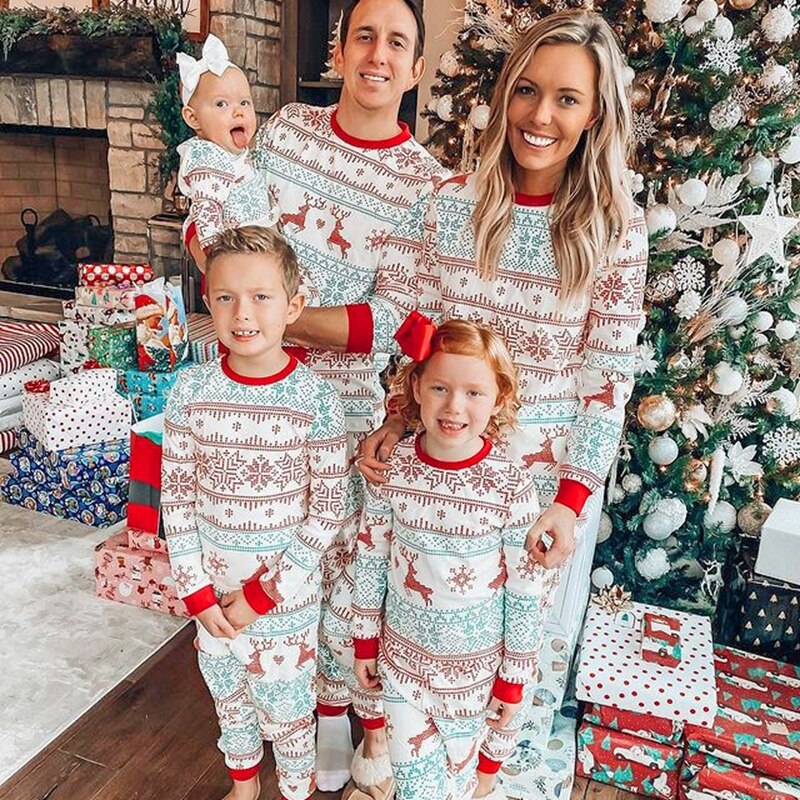 Happy family wearing matching Christmas pajamas with 'Ho Ho Ho' print, cozy cotton sleepwear for festive celebrations