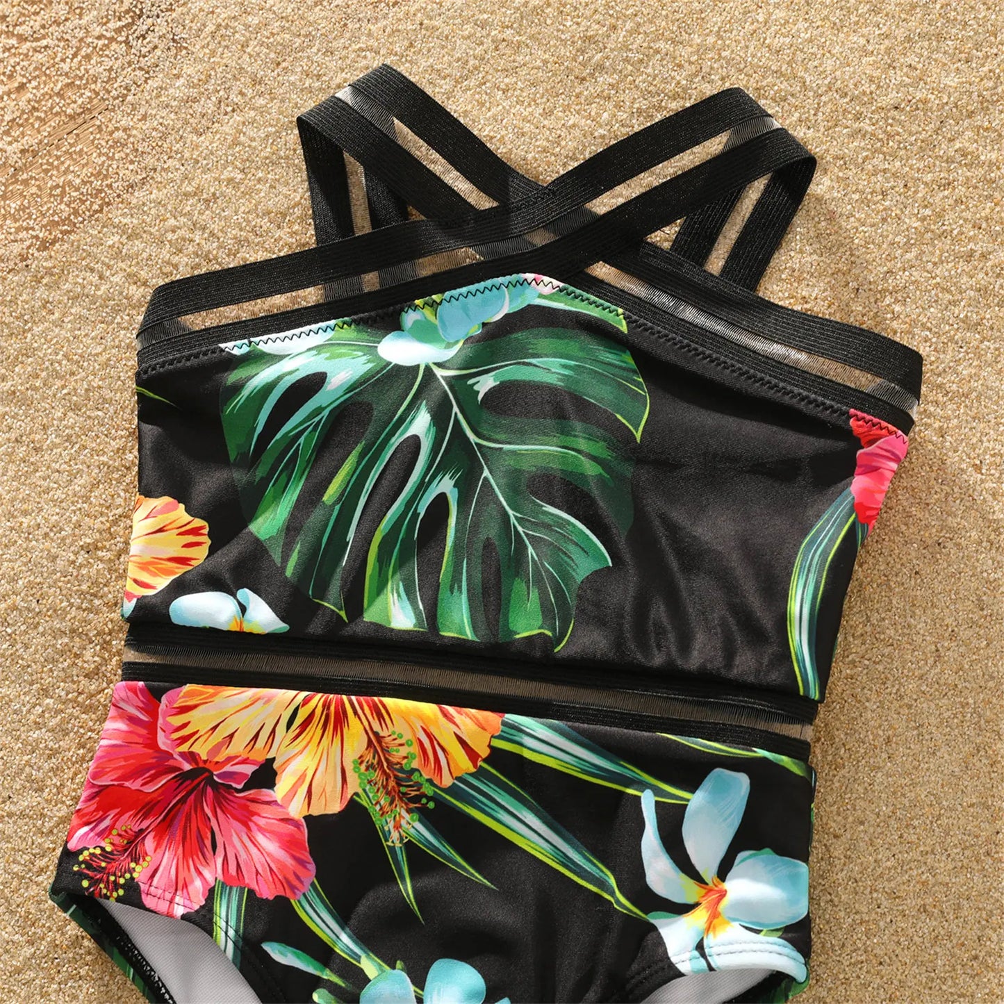 Close-up of coconut tree print fabric on matching family swimwear, highlighting tropical design and colors.