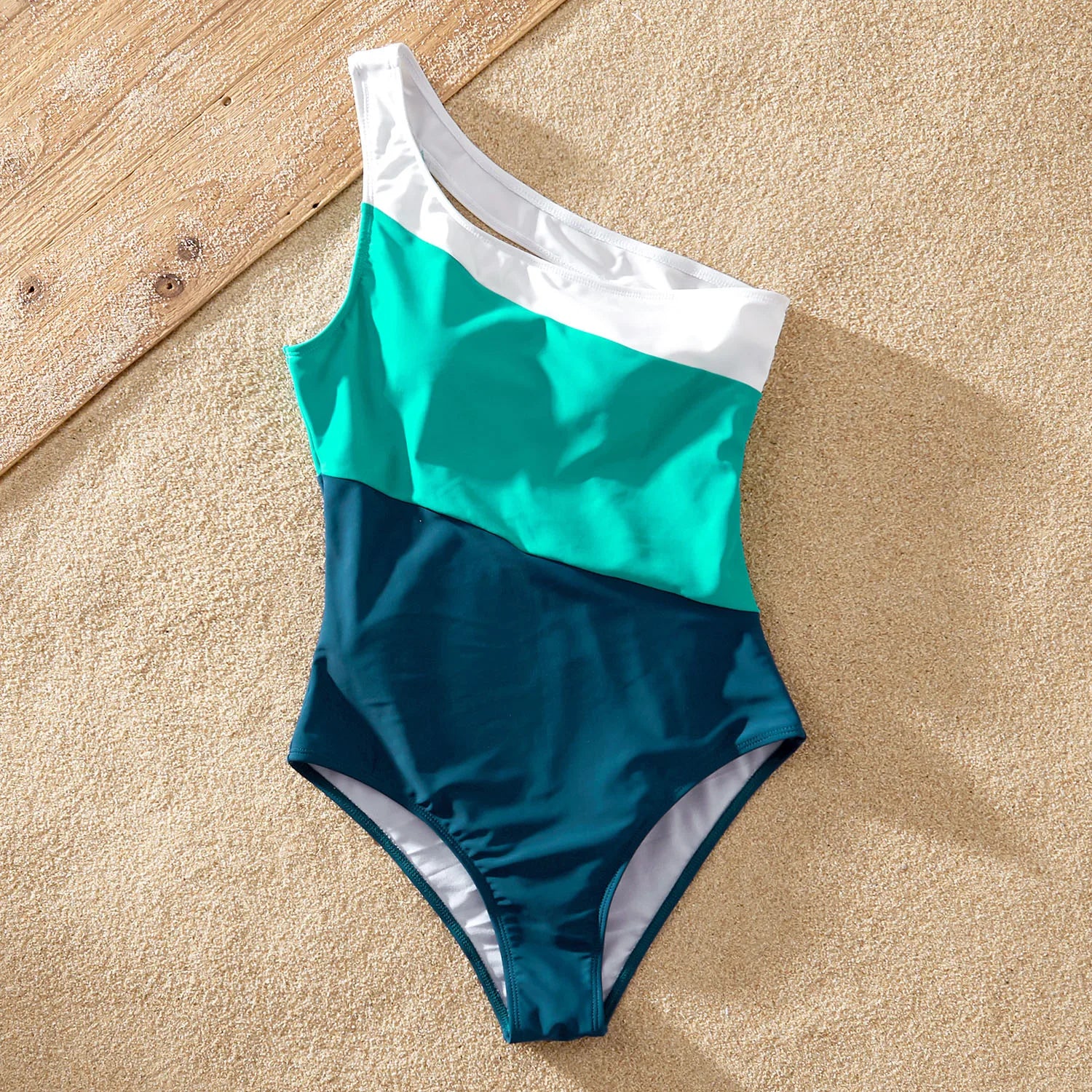 Kids in bright color block swimsuits building a sandcastle, perfect for their summer vacation