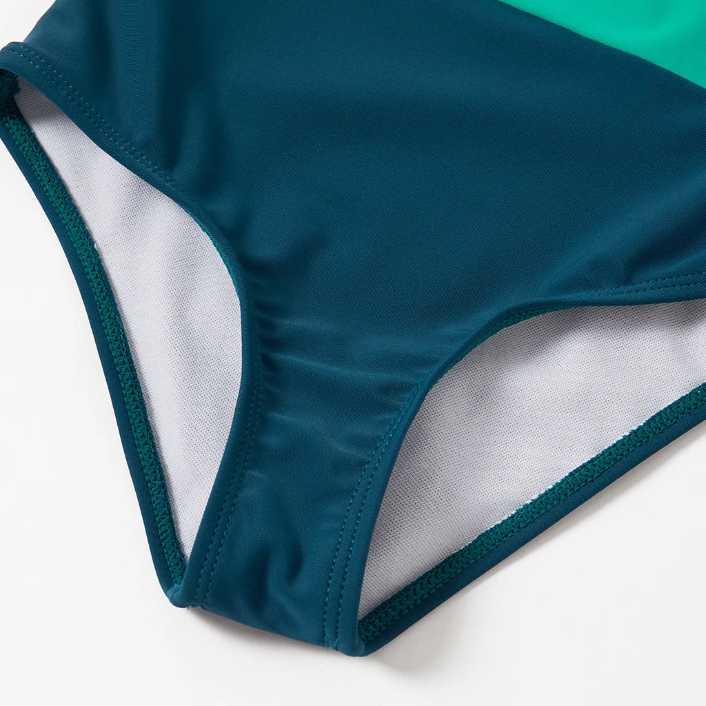 Set of folded family color block swimwear, showing various sizes for family members, ready for travel