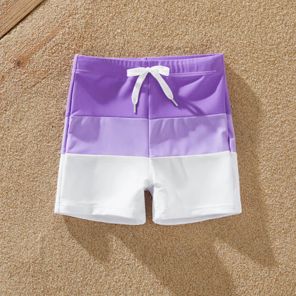 Dad and son wearing matching color-block swim trunks, perfect for summer