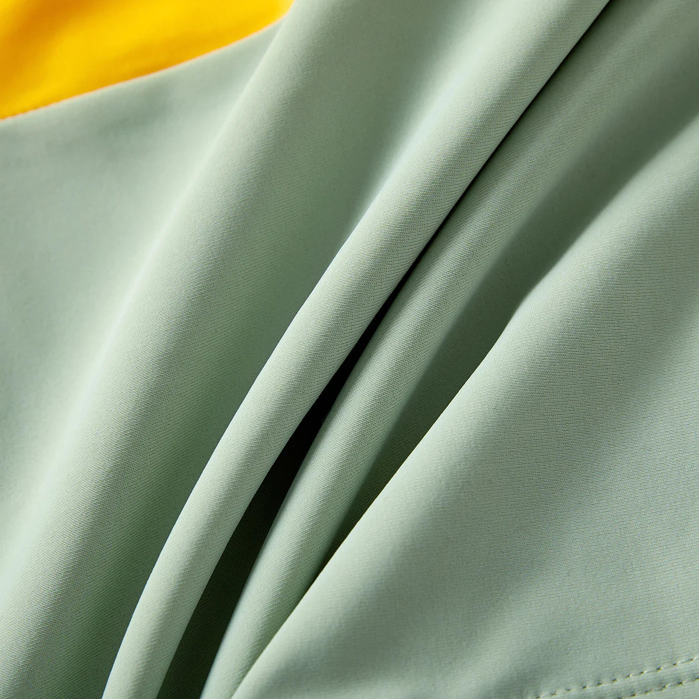 Close-up of vibrant colorblock pattern on family's matching one-shoulder swimsuits & trunks