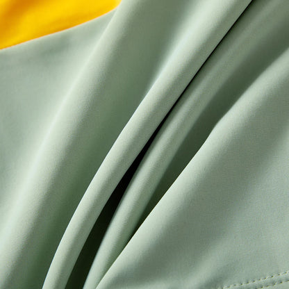 Close-up of vibrant colorblock pattern on family's matching one-shoulder swimsuits & trunks