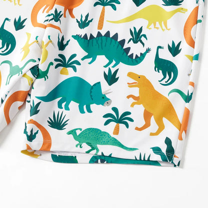 Woman in a blue dinosaur print one-piece swimsuit, relaxing on a lounge chair by the ocean.