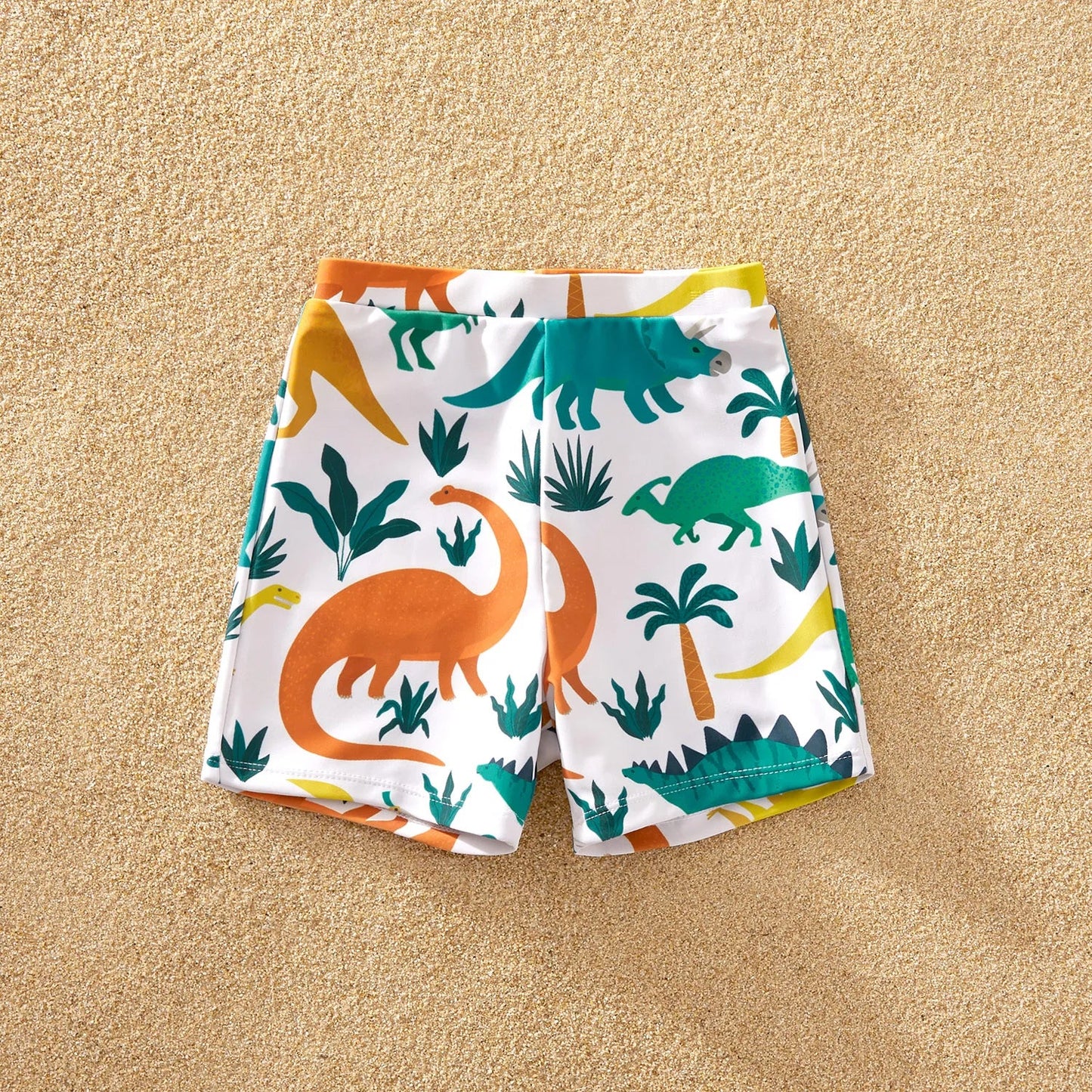 Teenage girl posing in a stylish dinosaur print one-piece swimsuit, ideal for beach fashion.