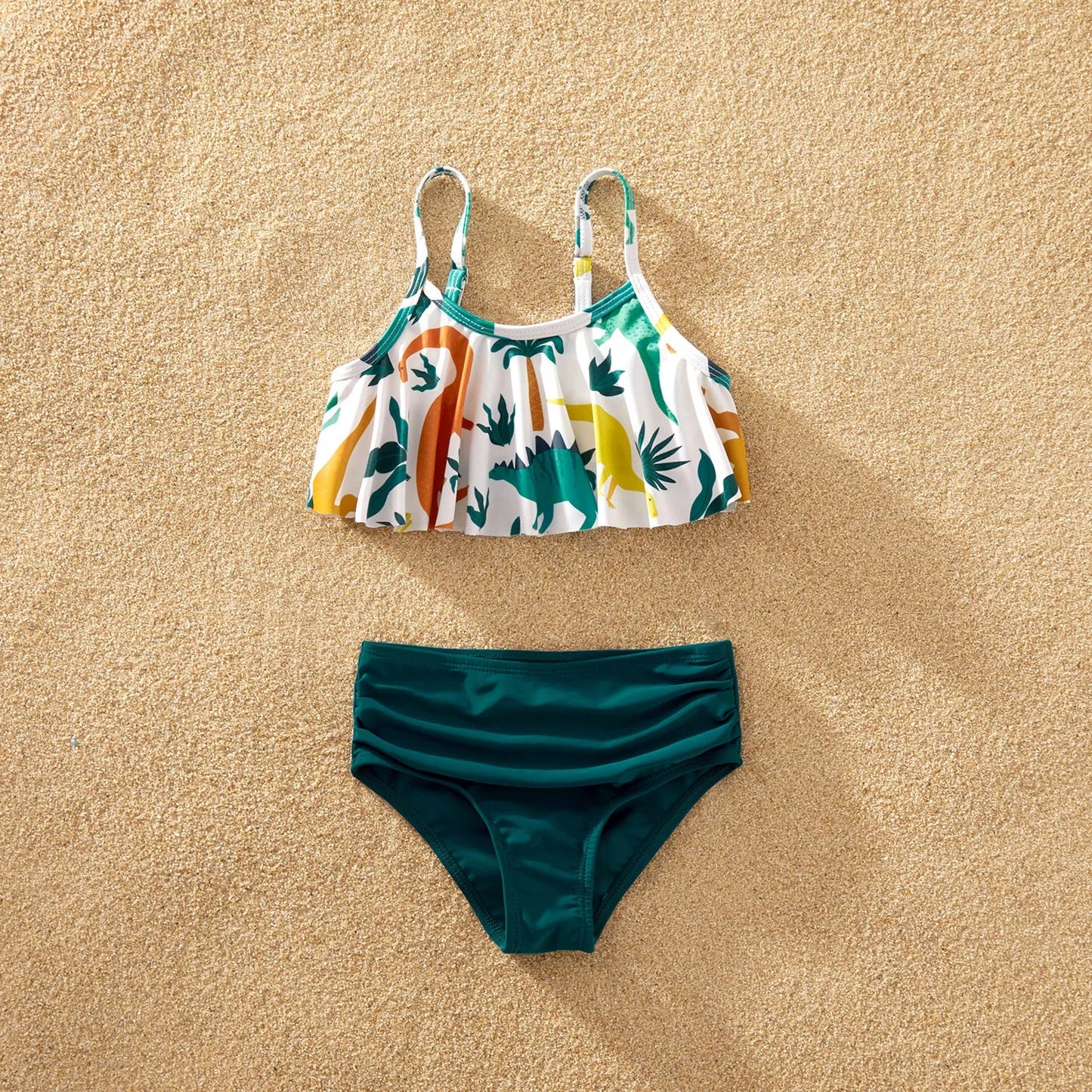 Close-up of blue dinosaur print fabric on family matching swimwear, showing texture and detail.