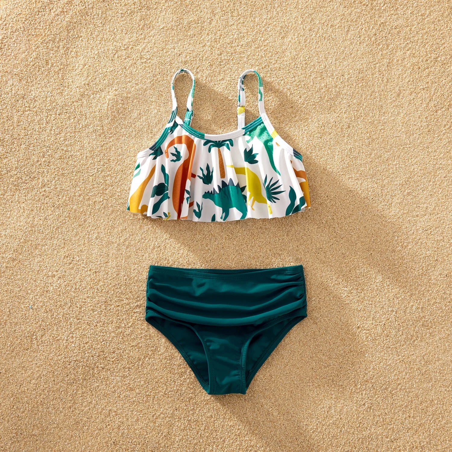 Close-up of blue dinosaur print fabric on family matching swimwear, showing texture and detail.