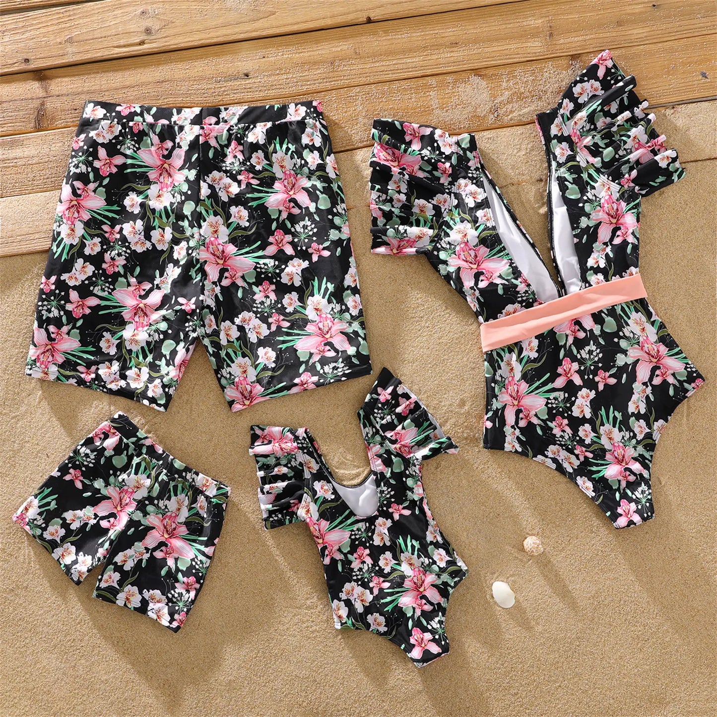Mother and daughter in matching floral ruffle sleeve one-piece swimsuits, vacation-ready.