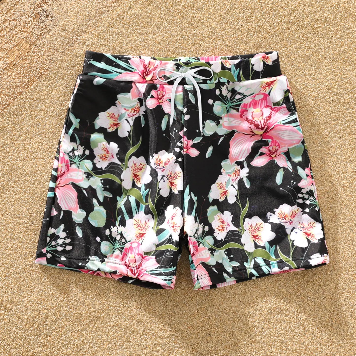 Close-up of vibrant floral print on matching family swimsuits for summer pool attire.