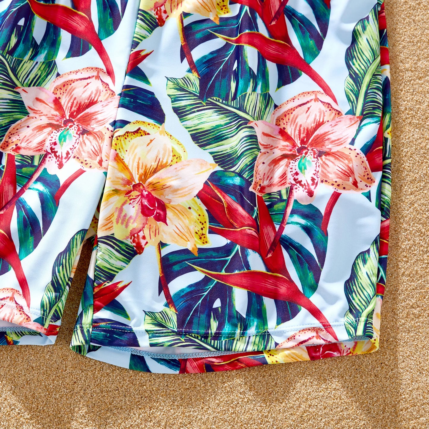 Set of family matching red floral swimwear including swimsuits and cover-ups.