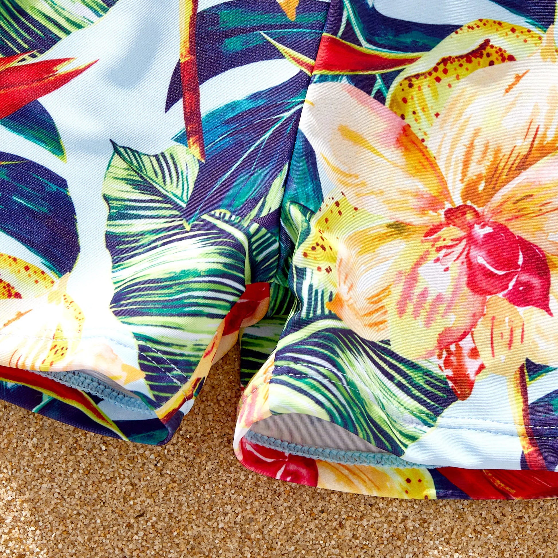 Red floral swim trunks and bikini, perfectly coordinated for family beach style.