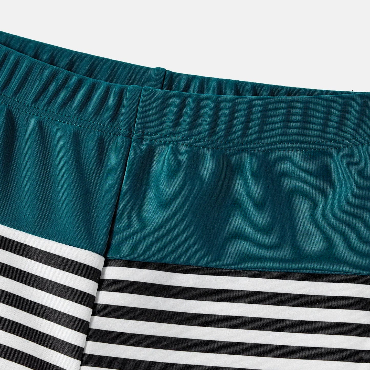 Infant in a cute green one-shoulder swimsuit, part of a family matching set