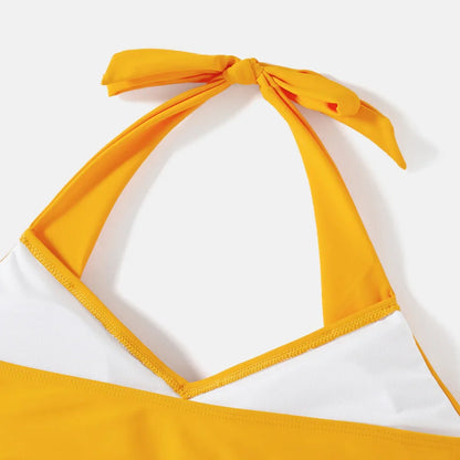 Close-up of lemon print fabric on family matching swimwear, vibrant design.
