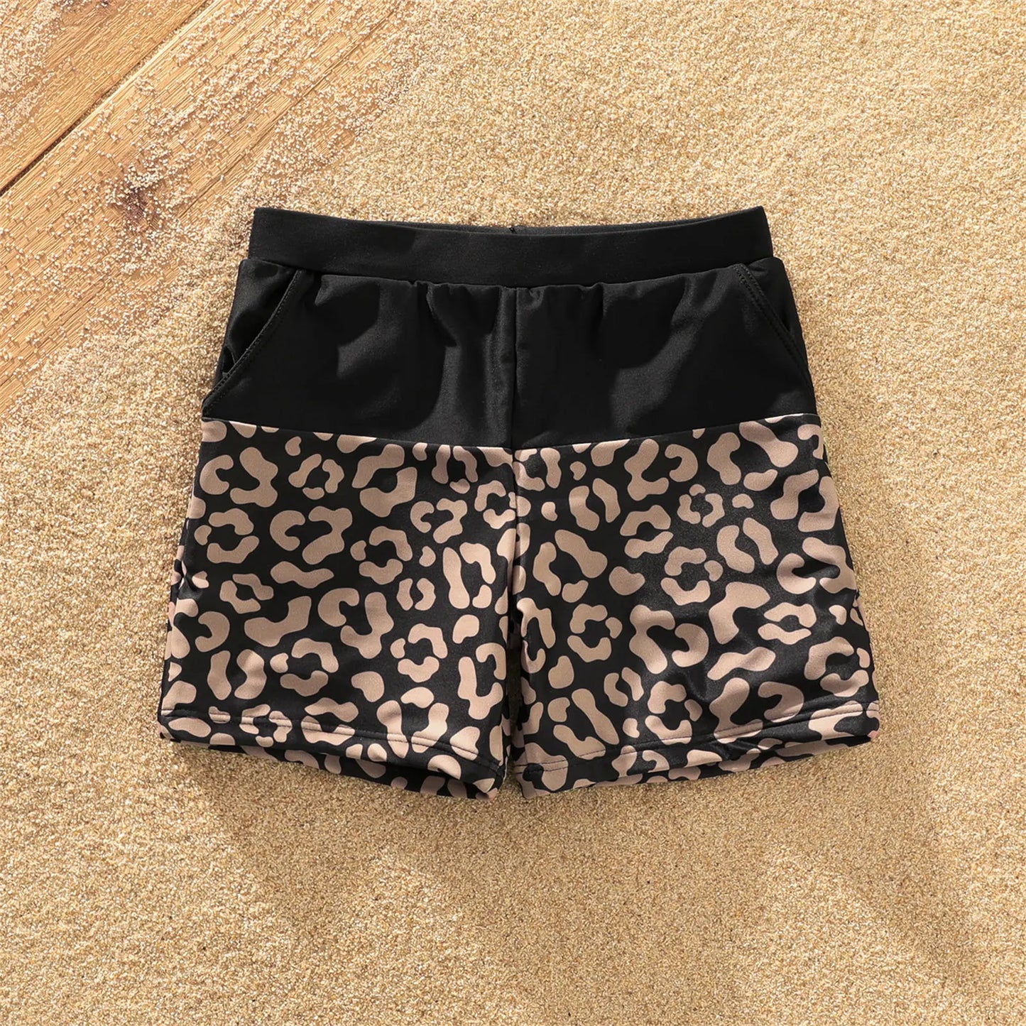 One-shoulder leopard print swimsuit with tie detail and coordinated men's swim trunks
