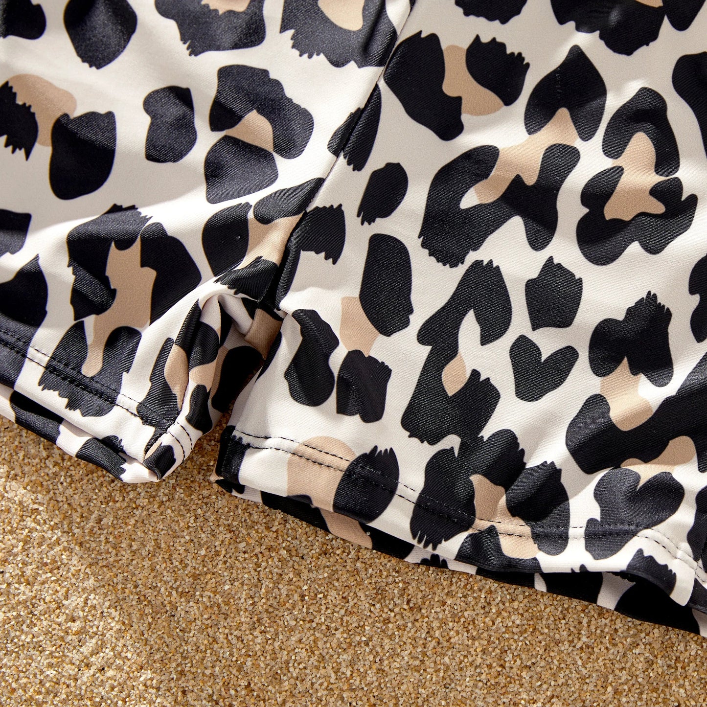 Leopard print women's bikini, men's swim trunks, and kids' swimwear for family matching