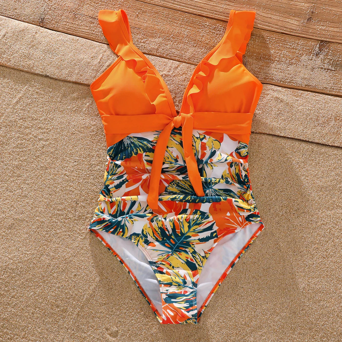 Matching orange tropical print swimsuits for the whole family's summer fun.