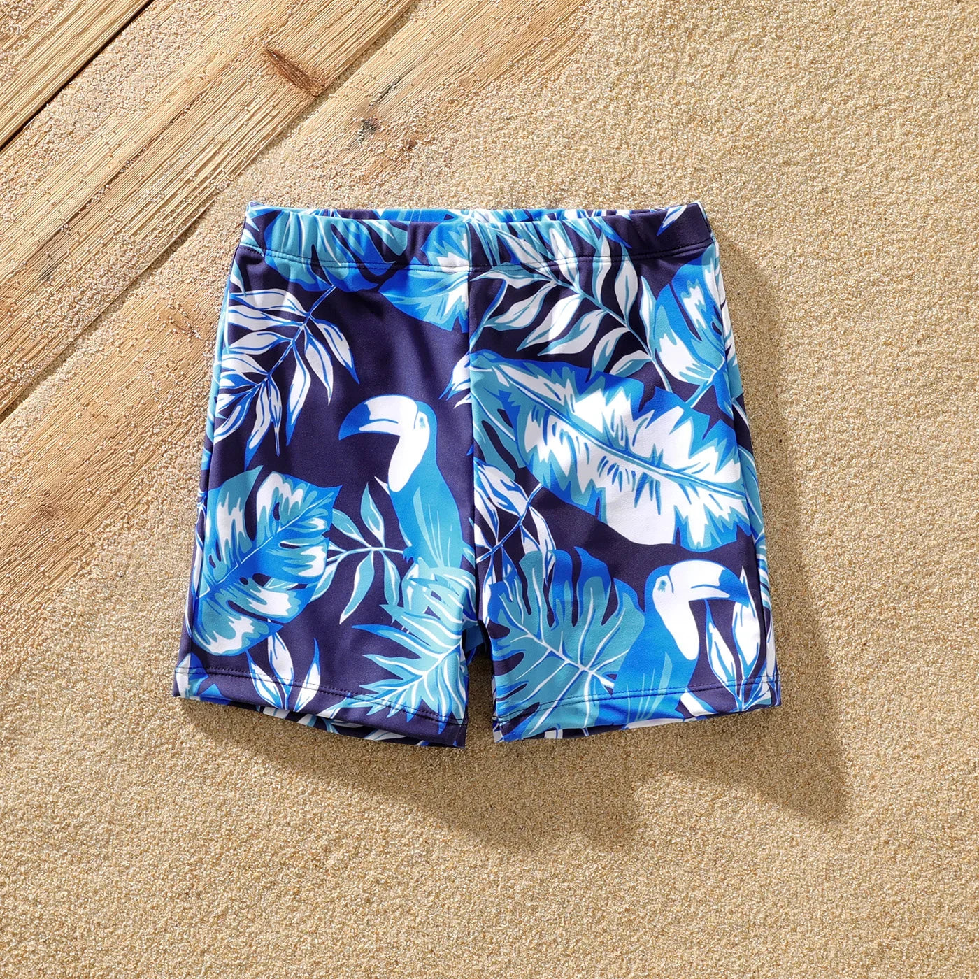 Kids, women's, and men's matching swimsuits featuring a lively palm print