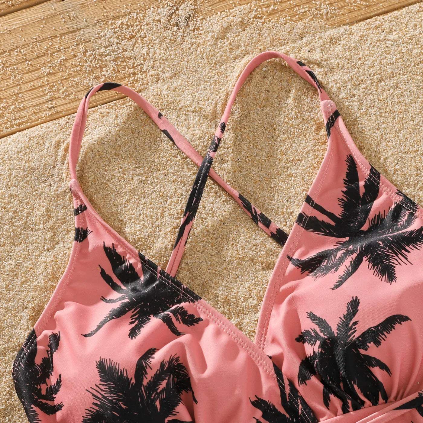 Mom and daughter matching pink bikini with tropical coconut tree pattern