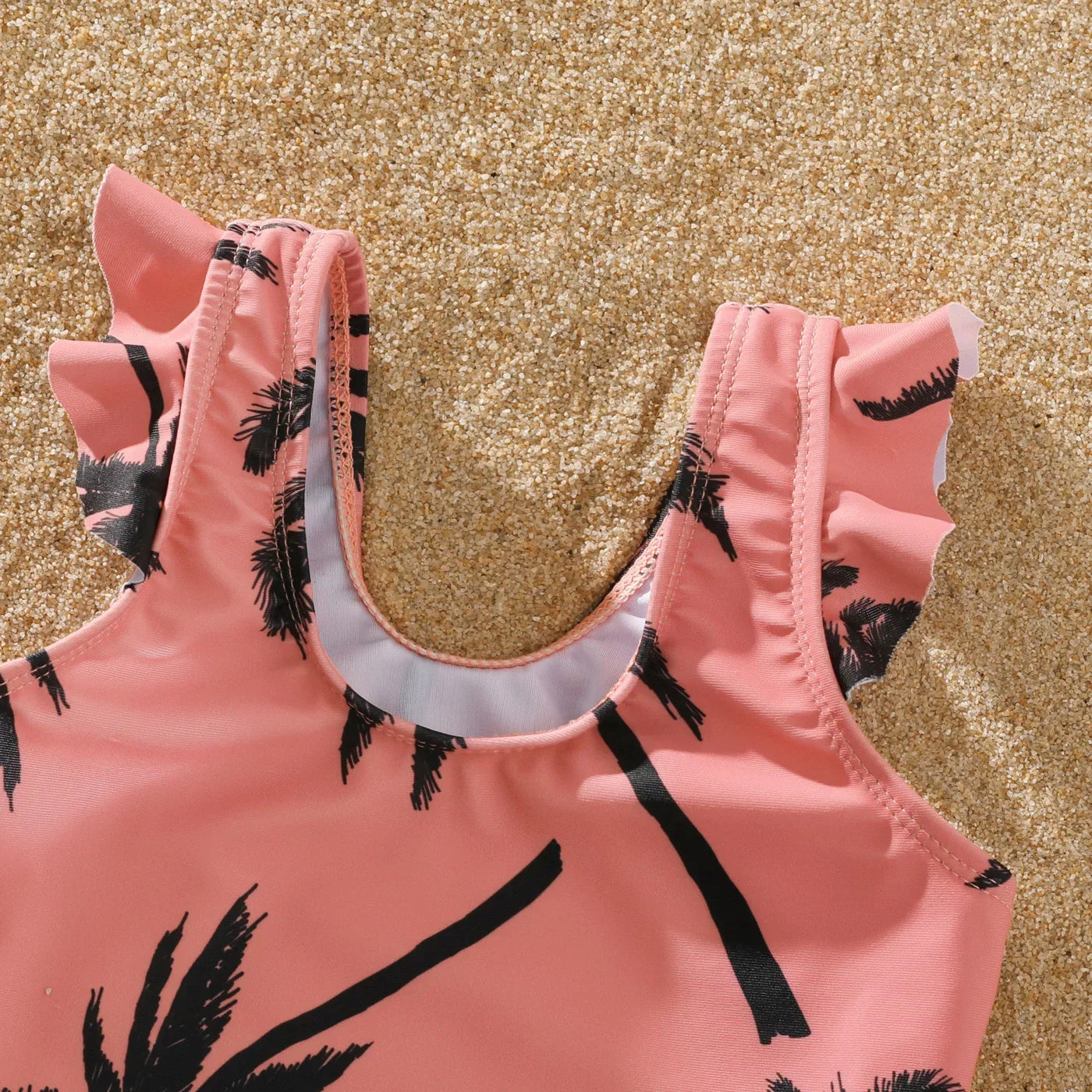 Toddler girl's pink coconut tree swimsuit, perfect for family pool time