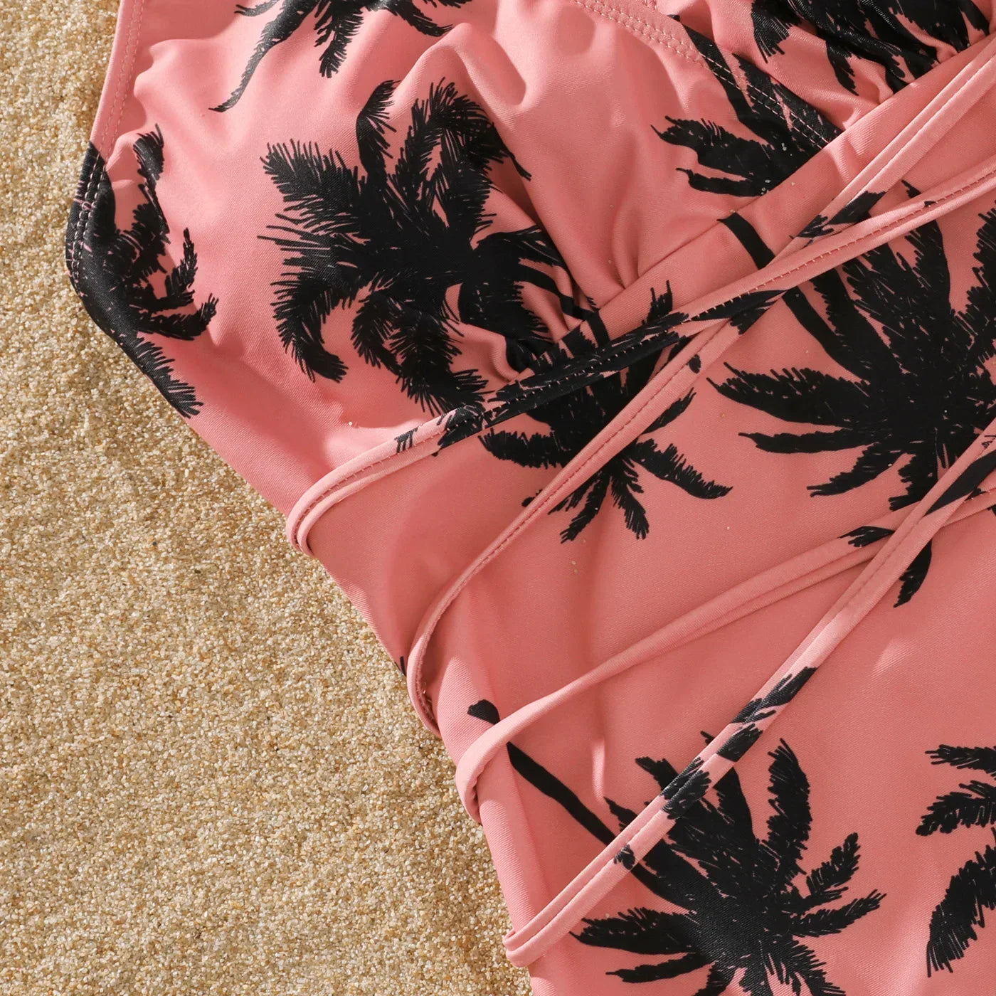 Girl's cute pink swimsuit with coconut trees, part of a family matching set