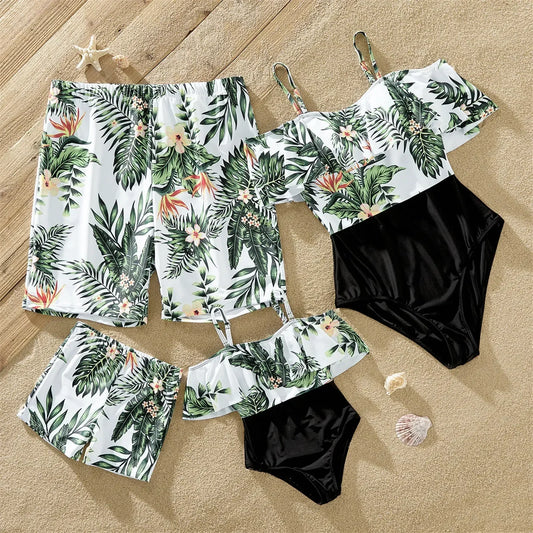 Family matching plant print swimsuit set on a beach, tropical summer outfits for parents & kids