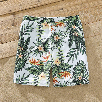 Family on a sandy beach, all wearing their matching plant print swimsuits, summer vacation goals