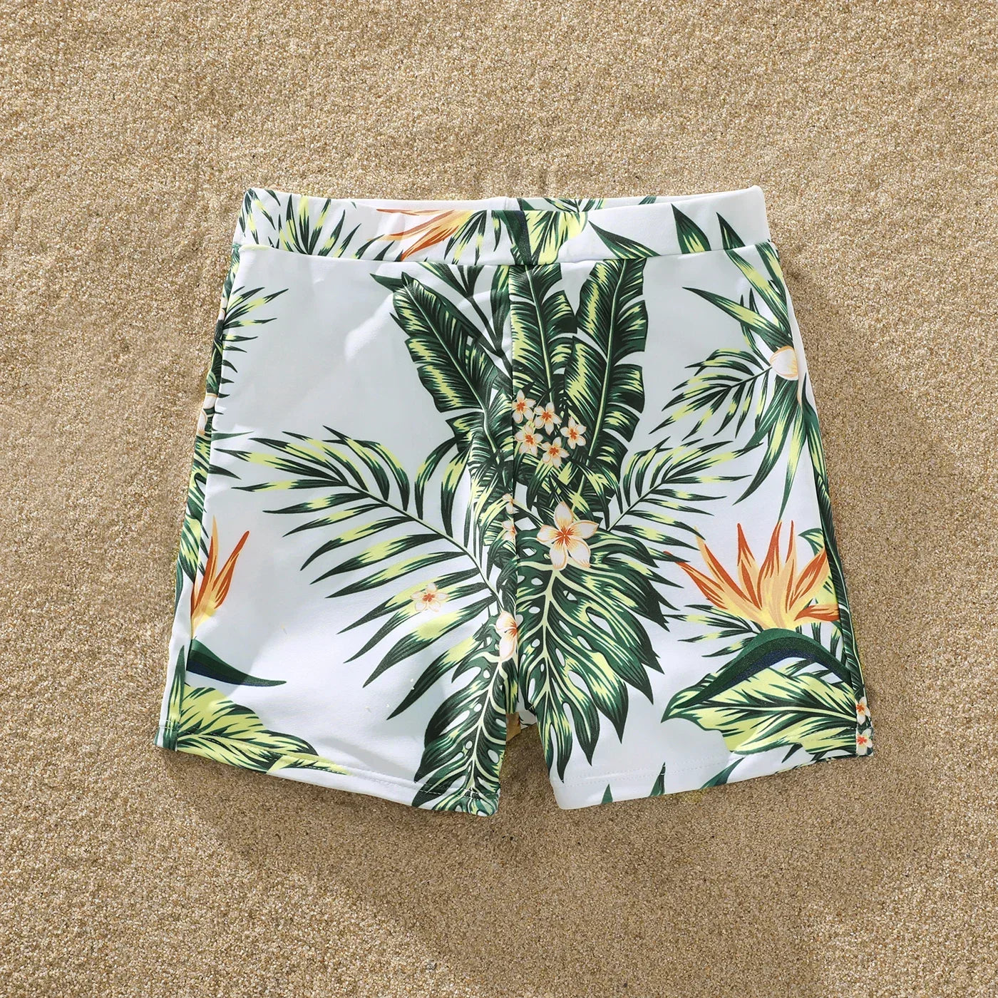 Woman in a plant print ruffle swimsuit, holding a tropical drink, perfect for beach relaxation
