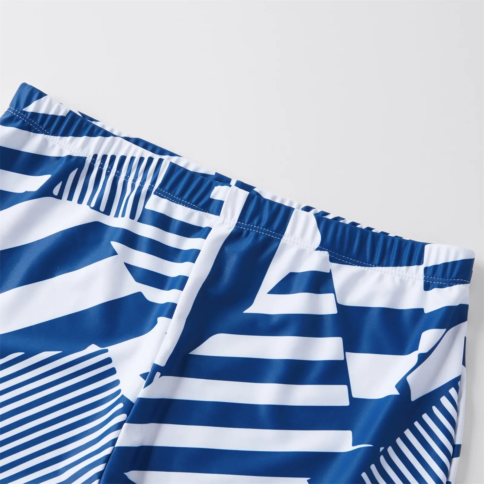 Family in coordinated ruffled swimsuits and swim trunks, ready for a summer vacation