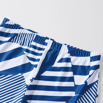 Family in coordinated ruffled swimsuits and swim trunks, ready for a summer vacation