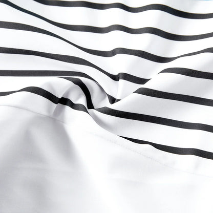 Family modeling striped beach outfits, emphasizing fun and togetherness on holiday